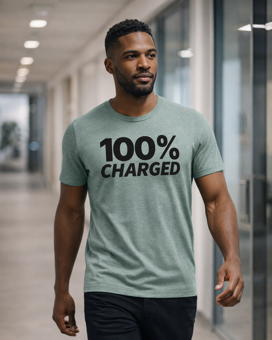 Man wearing a light green t-shirt with '100% Charged' text in a modern indoor setting