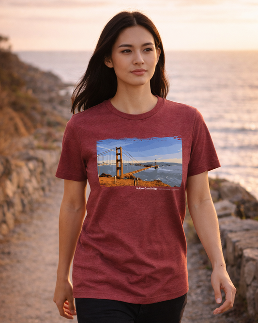 Woman wearing a maroon t-shirt with a graphic of the Golden Gate Bridge by the ocean.
