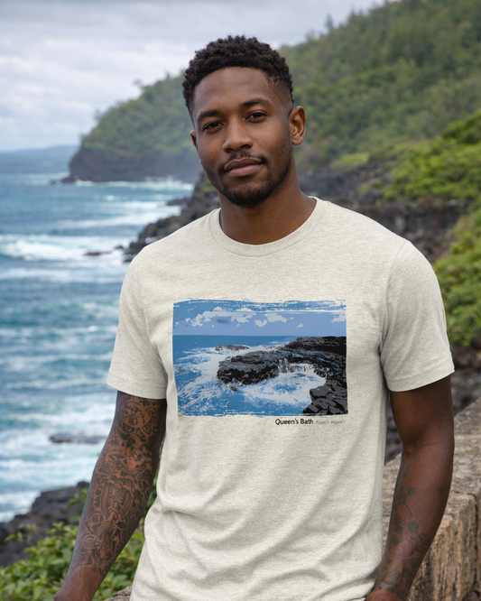 Man wearing a t-shirt with a scenic print, standing in front of ocean and cliffs.