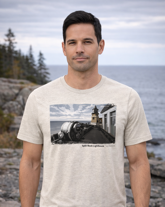 Man wearing a t-shirt with a lighthouse graphic on a rocky coastal background