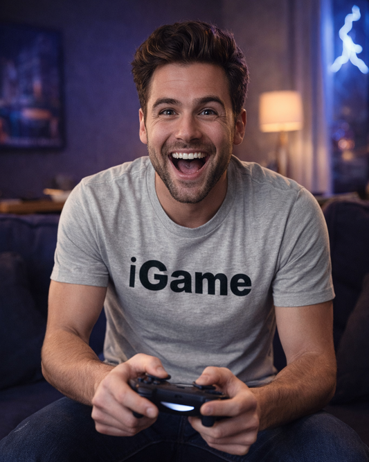 Man wearing a 'iGame' t-shirt holding a gaming controller in a room with a neon sign.