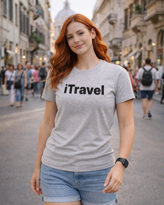Woman wearing a gray t-shirt with 'iTravel' text on a city street.