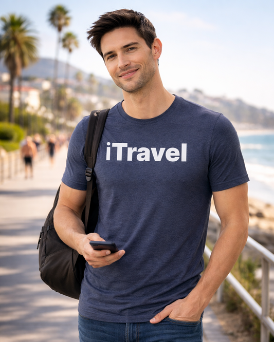 Man wearing a navy blue 'iTravel' t-shirt by the beach.